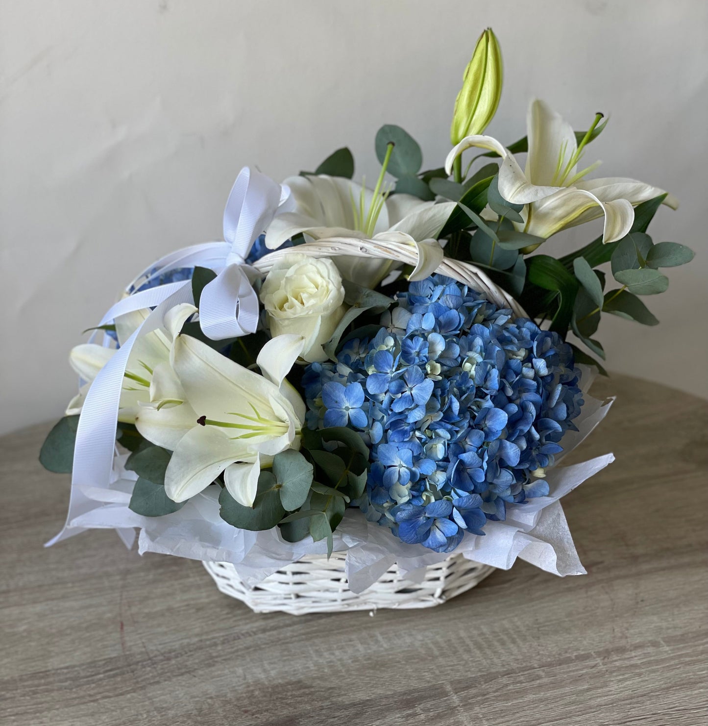 Blue hydrangeas and white lilies basket arrangement by Magic Flor Dubai