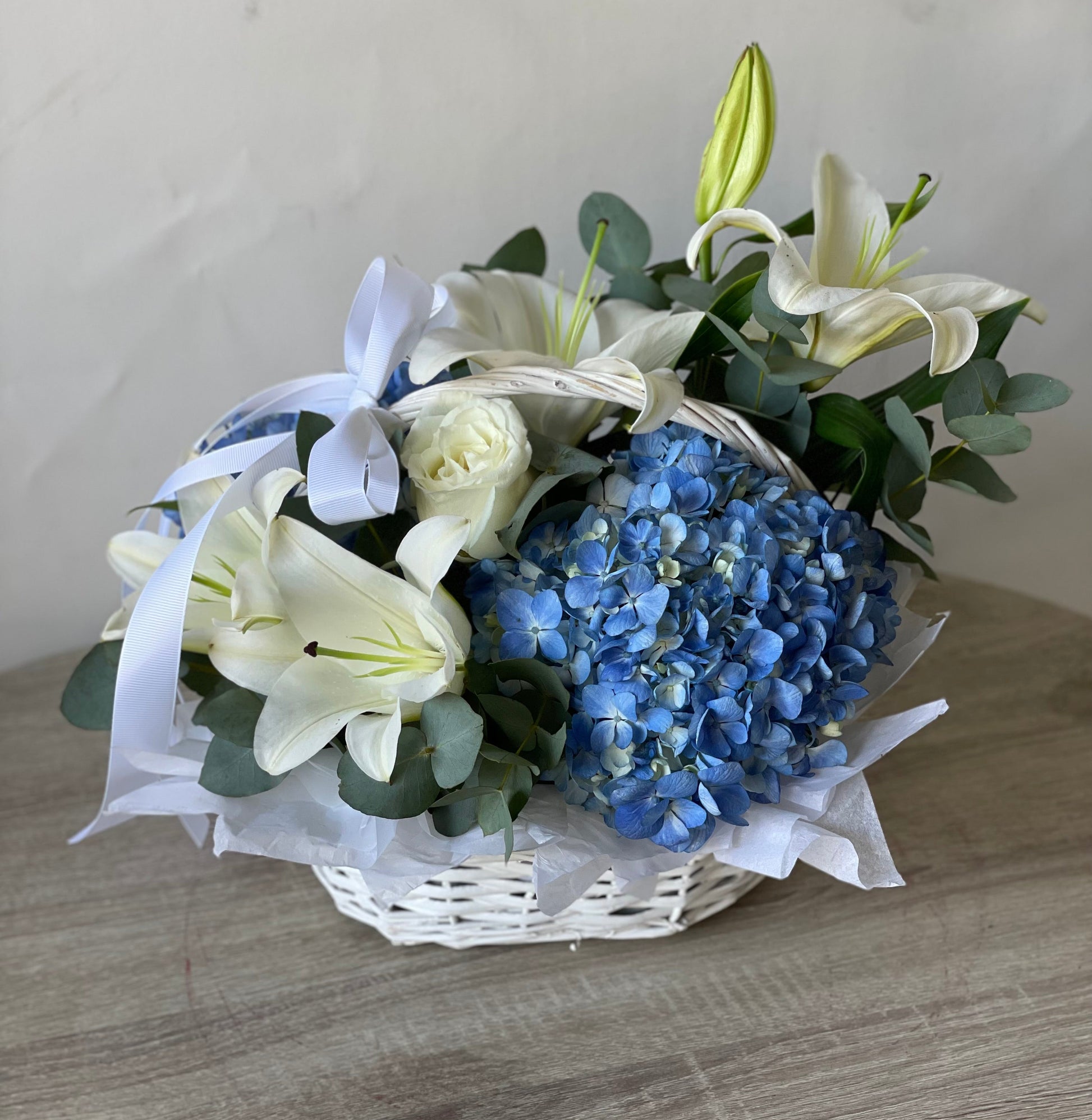 Blue hydrangeas and white lilies basket arrangement by Magic Flor Dubai